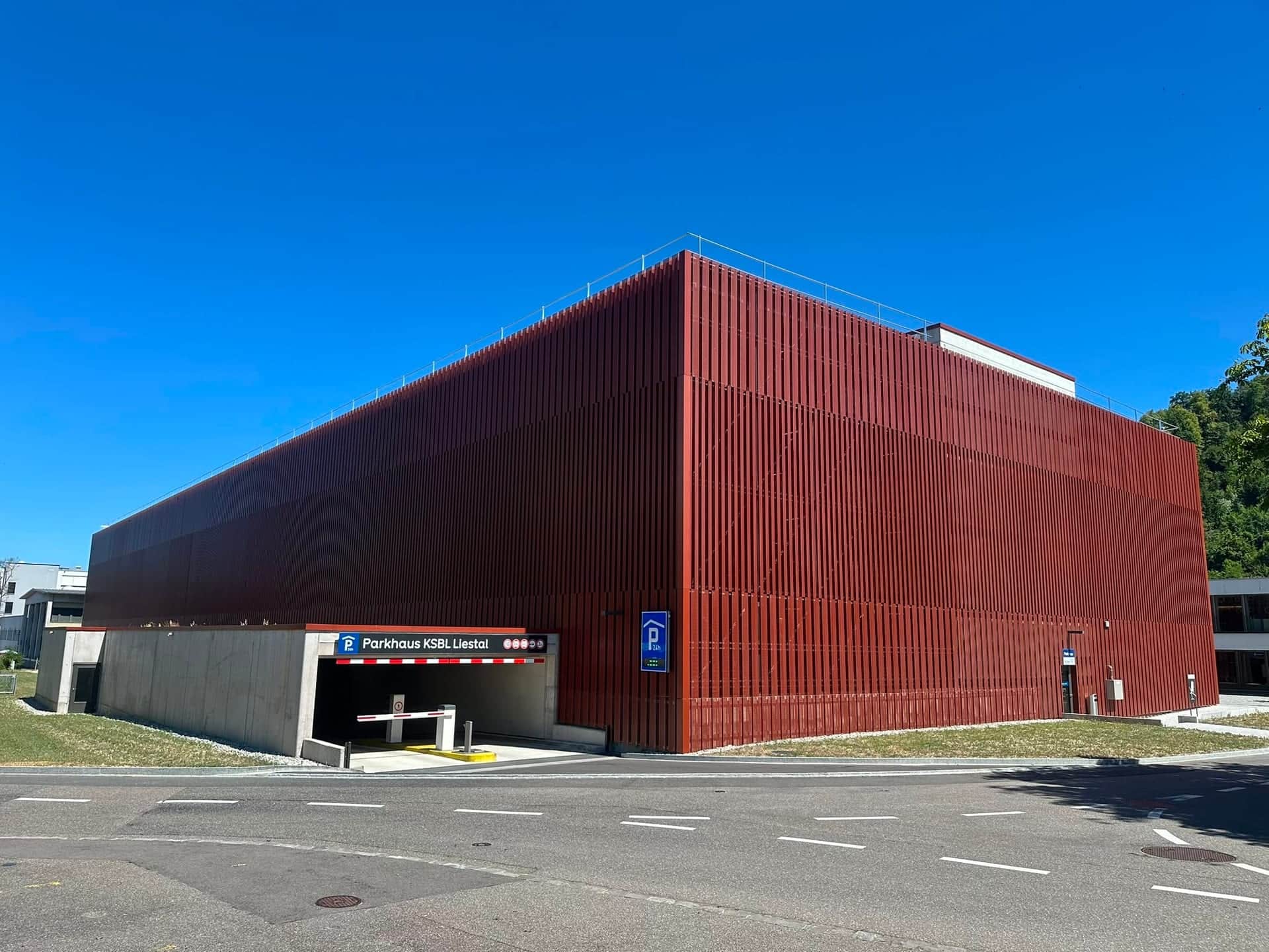 Parkhaus mit rostroter Metall-Lamellenfassade, Ansicht der Längsseite