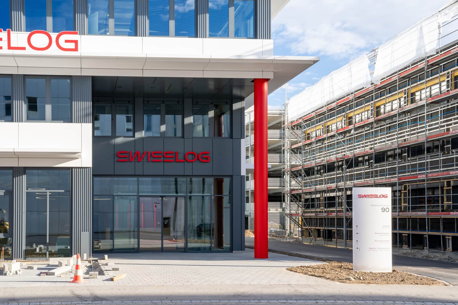 Eingangsbereich mit Vordach und Metallfassade in Anthrazit und Weiss
