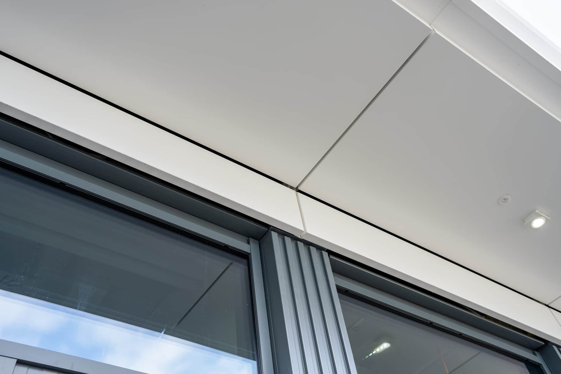 Detail der Untersicht mit Fugen der Metallverkleidung über dem Fensterband