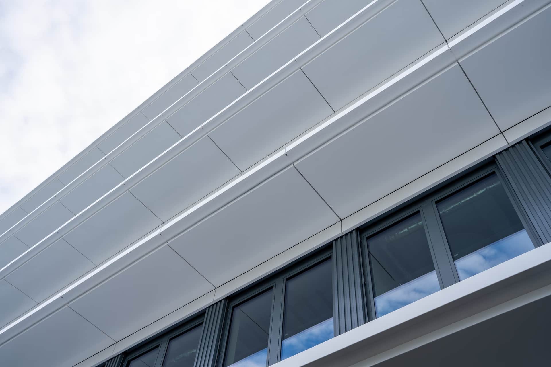Untersicht der weissen Metallverkleidung an auskragenden Fassadenbändern